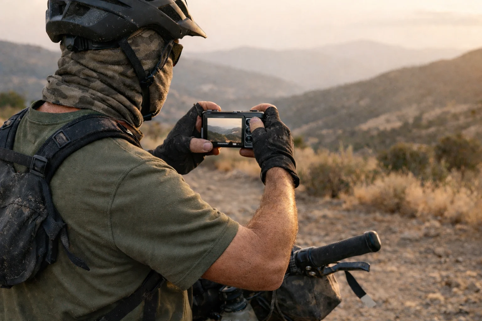 Ultralight camera kit for bikepacking: Sony RX100 VII pulled from jersey pocket on a loaded bikepacking bike at golden hour on a gravel trail